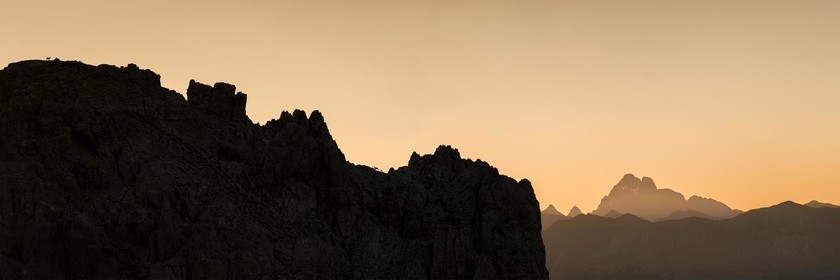 Trois chamois courent sur les crêtent au lever de soleil.