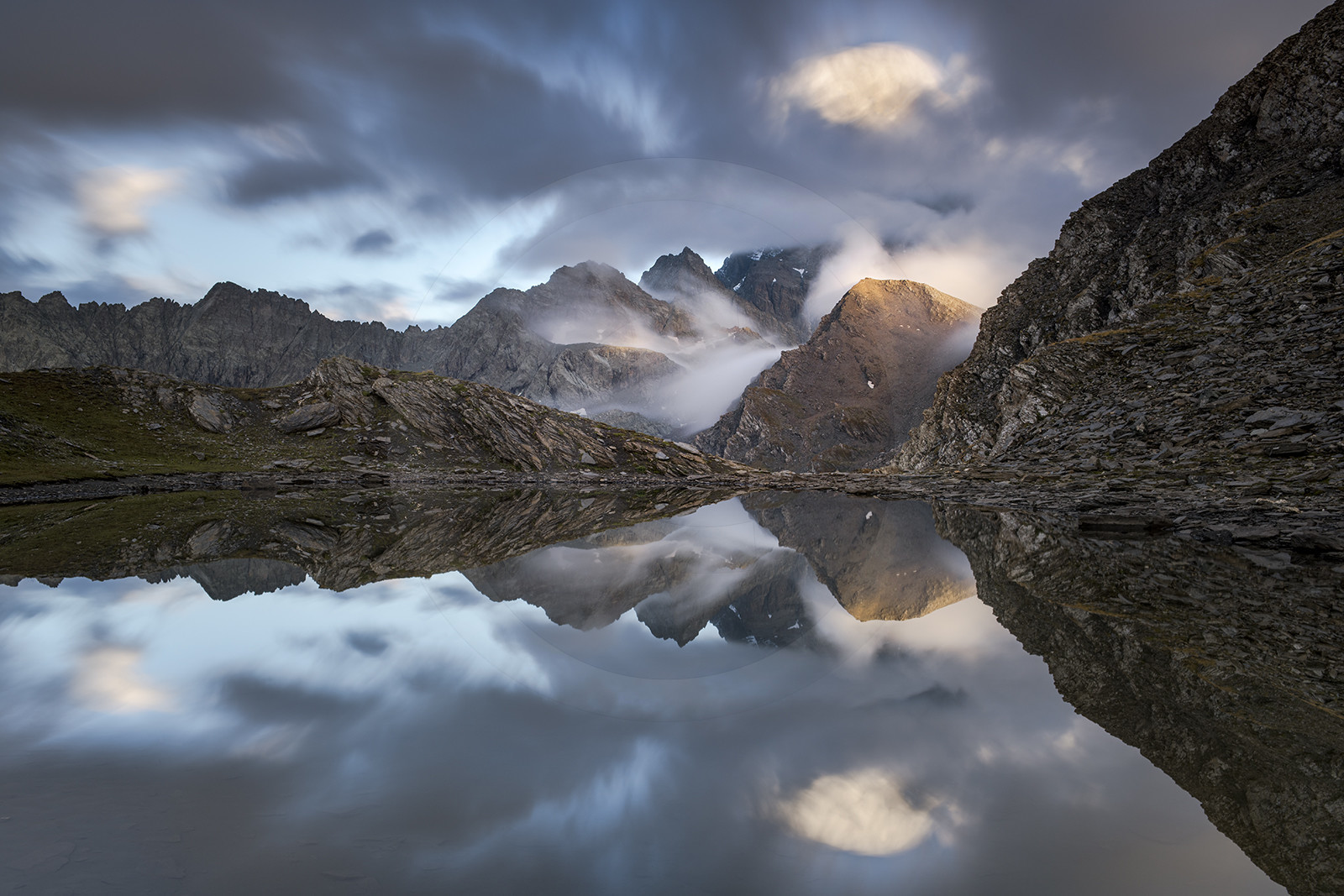 reflet dans le lac de Clot Sablé du mont Viso qui se cache dans la nebbia,